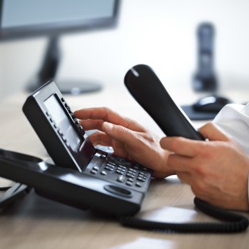 1-voip service review voip services man dialing number on voip phone in office
